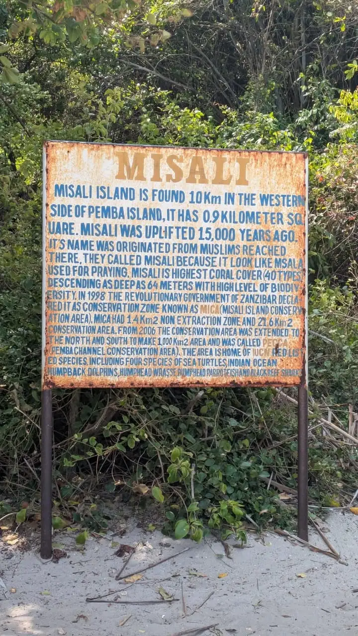 The weathered Misali Island information board, describing the island's coral cover and conservation area.